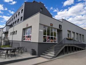 a building with tables and chairs in front of it at FB Apartamentai in Plungė