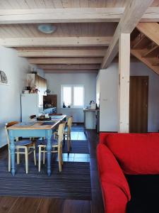 a living room with a table and a red couch at Chalupa Nad Hladinou in Teplice nad Metují