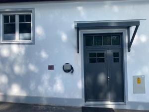 a white house with a door and a window at ParkSuite Aflenz Kurort in Aflenz Kurort