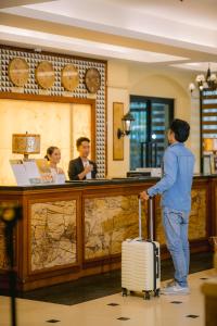 a man with a suitcase standing in front of a counter at Sunlight Hotel Coron in Coron +48 photos