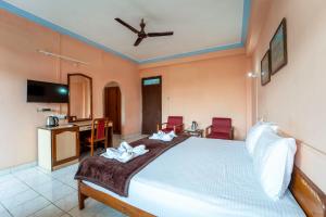 a bedroom with a bed and a desk and chairs at Vasco Residency in Vasco Da Gama
