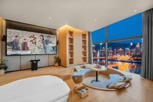 a living room with a large window and a tv at ChongQing BackHome Riverview Hotel in Chongqing