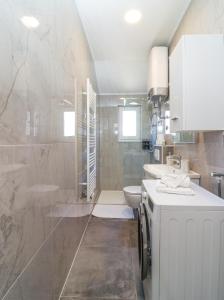 a white bathroom with a toilet and a sink at D&J Apartments in Primošten +31 photos