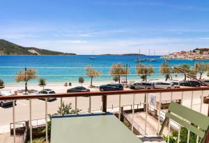 a balcony with a view of a beach and the water at D&J Apartments in Primošten