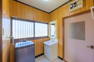 a bathroom with a toilet and a sink and a window at もくハウス in Kamifukuoka