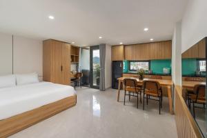 a bedroom with a bed and a kitchen with a table at Ngoc Thuong Hotel & Apartment- Han River View in Danang