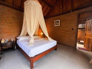 a bedroom with a bed with a mosquito net at Tuka Cabins in Jatiluwih