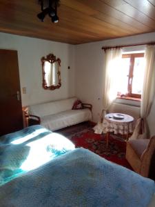 a bedroom with a bed and a couch and a window at Pension Unterleiten in Ramsau +29 photos