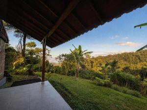 a porch of a house with a view of a garden at Tuka Cabins in Jatiluwih