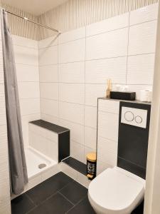 a white bathroom with a toilet and a shower at Luxsuite Studio Oberhausen Centro Bahnhof in Oberhausen +18 photos