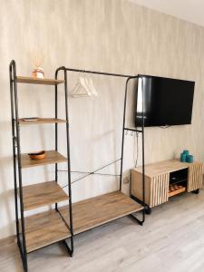 a tv stand with a shelf and a television at Luxsuite Studio Oberhausen Centro Bahnhof in Oberhausen