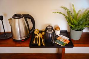 a tray with a tea kettle and utensils on a table at Mi Casa Coastal Villa in Akurala