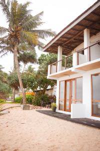 a house on the beach with a palm tree at Mi Casa Coastal Villa in Akurala