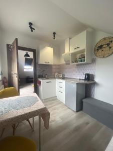 a kitchen with white cabinets and a table in a room at Apartament Teo -Rewal in Rewal