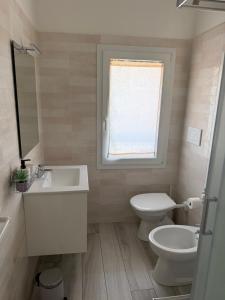 a bathroom with a sink and a toilet and a window at Terrazza Montegrappa in Reggio Emilia +12 photos