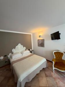 a bedroom with a bed and a tv and a chair at Da Noi Due in Bergamo