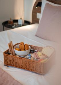 a tray with food and a bowl of food on a bed at The Wave in Limenaria