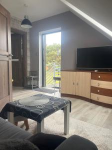 a living room with a tv and a coffee table at Apartament Teo -Rewal in Rewal
