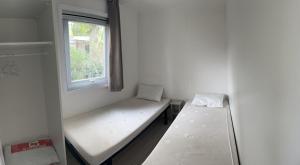a small room with two beds and a window at rouge gorge in Valras-Plage