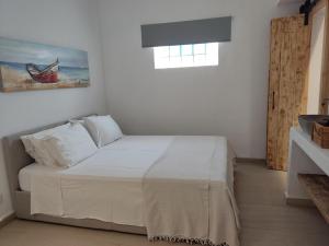 a bedroom with a bed in a white room at Votsalon Beach House - 30 meters from Alykes Beach in Katastárion