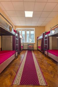 a room with three bunk beds and a rug at Kaunas Center Hostel - Self-Check In in Kaunas