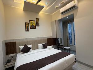 a bedroom with a large bed in a room at Hotel Maniratna Premium in Indore
