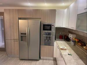 a kitchen with a stainless steel refrigerator and a microwave at Beautiful villa with pool KELIBIA in Kelibia