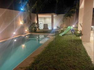 a swimming pool with a slide in a house at night at Beautiful villa with pool KELIBIA in Kelibia