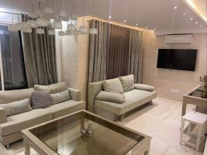 a living room with two couches and a tv at Beautiful villa with pool KELIBIA in Kelibia