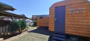 a wooden shed on the side of a house at Tiny House auf der Kingswood Ranch in Cornberg