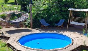 a pool with a hammock and two chairs and a hammock at Tiny House auf der Kingswood Ranch in Cornberg