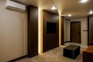 a room with a tv and a door with a couch at Air Kostanay in Kostanay