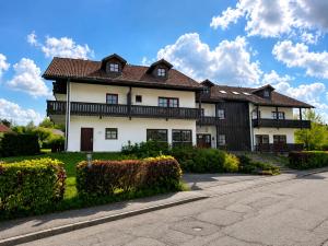a large white house with a brown roof at Falkenstein Loft 55 in Zwiesel