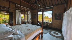 a bedroom with a bed in a room with windows at Bali Firefly BnB in Ubud +39 photos