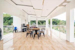 an open living room with a table and chairs at SMyleINN Farm in San Fernando