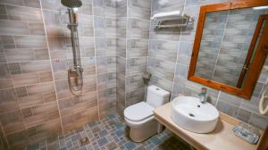 a bathroom with a toilet and a sink and a shower at 八零年代客栈 in Hanqiyu +9 photos