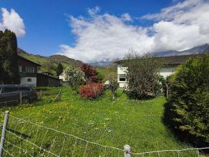 a yard with a fence in front of a house at Flumserberg pur, Auszeit am Walensee in Flums