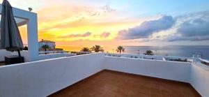 a balcony with a view of the ocean at sunset at Meerblick Pool Direkt am Strand in Cuevas del Almanzora