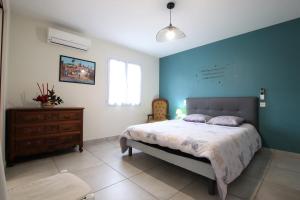 a bedroom with a bed and a wooden dresser at Hergarai in Saint-Jean-le-Vieux +32 photos