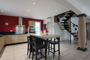 a kitchen with a table and a spiral staircase at Hergarai in Saint-Jean-le-Vieux