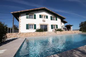 a villa with a swimming pool in front of a house at Hergarai in Saint-Jean-le-Vieux