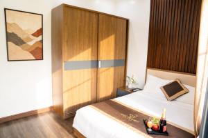 a bedroom with a bed with a wooden headboard at Hoàng Liên Hotel in Na Cốc