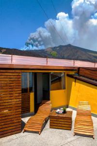 ein Haus mit vier Stühlen und einem Tisch auf einer Terrasse in der Unterkunft Corsaro Etna Hotel&SPA in Nicolosi