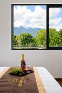 a table with a bottle of wine and a plate of fruit at Hoàng Liên Hotel in Na Cốc