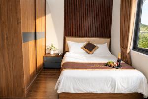 a bedroom with a bed with a bowl of fruit on it at Hoàng Liên Hotel in Na Cốc