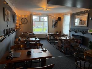 a restaurant with tables and chairs and a clock on the wall at The Queens Hotel Harlech in Harlech +50 photos