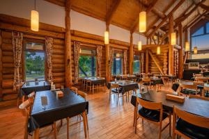 a restaurant with tables and chairs in a room with wooden walls at Log Hotel The Maple Lodge in Iwamizawa