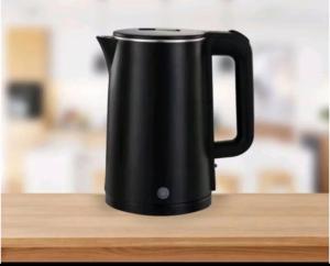 a black jug sitting on top of a wooden table at Lovisya Residence in Jakarta