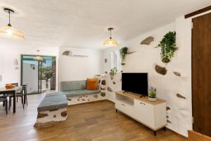 a living room with a tv and a couch and a table at Palmeral de Taidía in Taidía