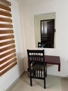 a black chair sitting next to a staircase with a mirror at Staio Rooms in Thodupuzha